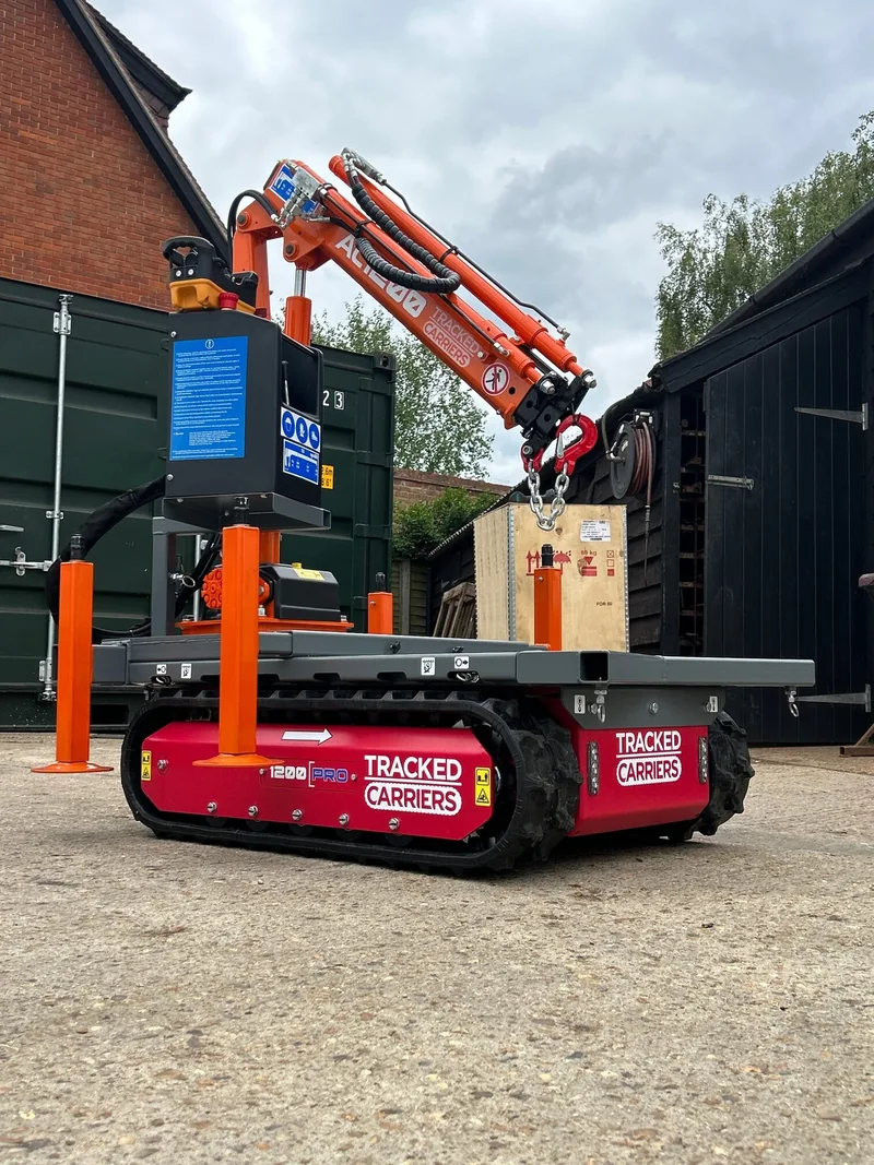 Tracked carrier with a mini crane arm on a residential driveway