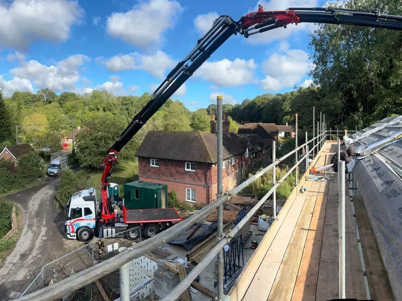 WB Services long reach Hiab lifting materials onto a scaffolded roof